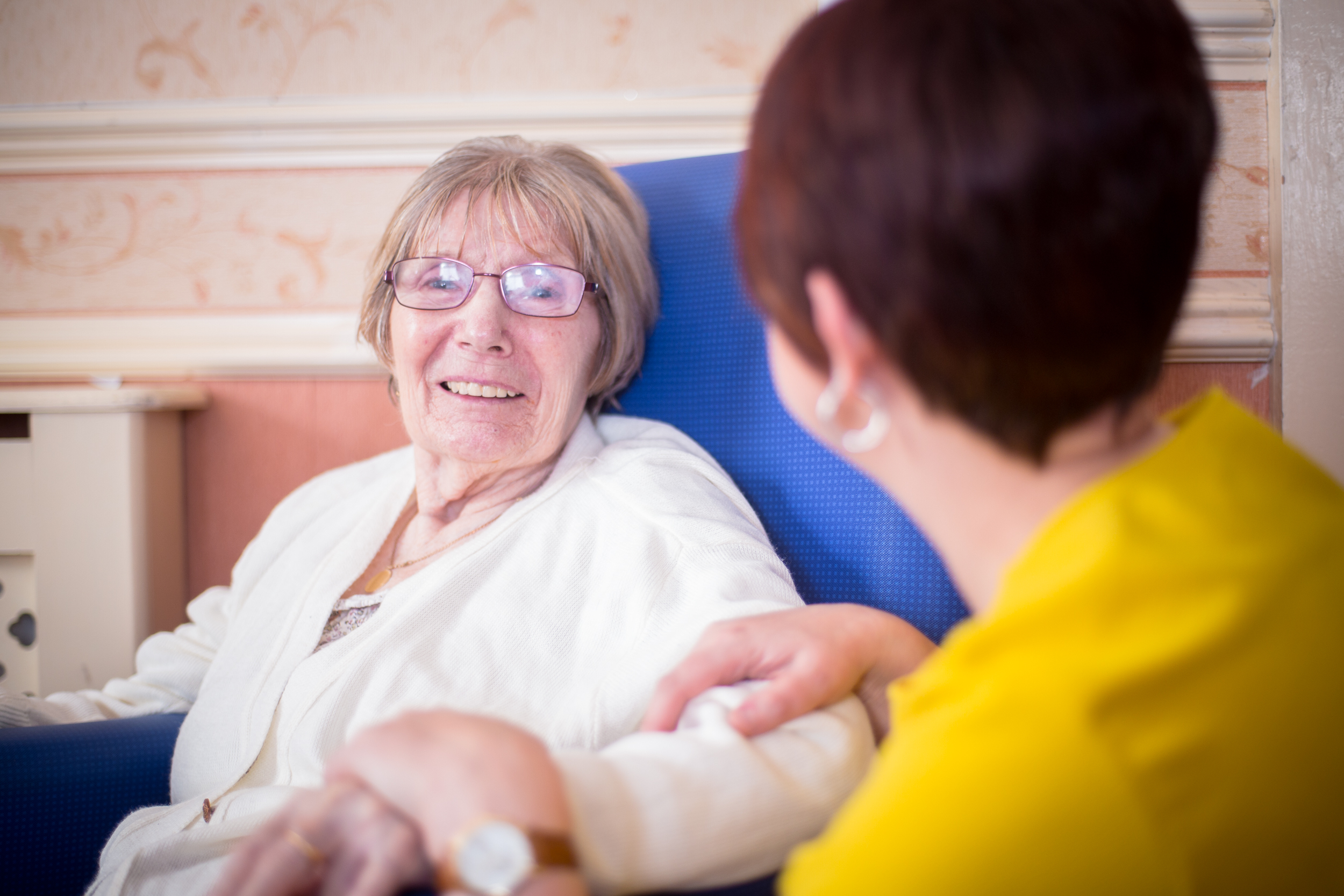 A resident laughing with a member of staff