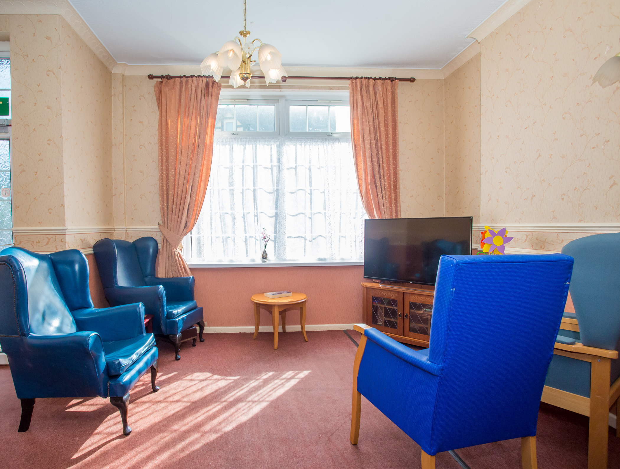 The lounge, with bright blue wing chairs
